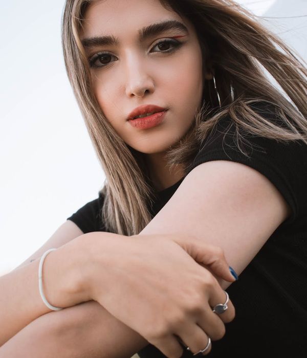 Woman in a calm, balanced pose against a dark background with apricot light.